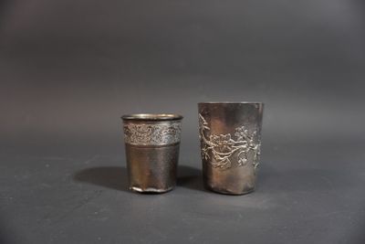 two silver cups sitting next to each other on a table