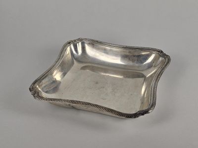 une assiette en argent dont le bord est orné de perles sur un fond blanc
