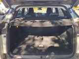 the back of a car with its trunk open on the side of the road