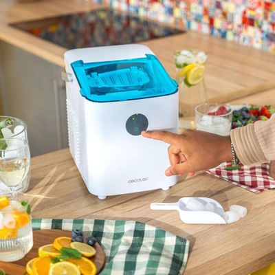 une personne qui montre du doigt un petit purificateur d'air posé sur le plan de travail de la cuisine