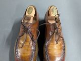 pair of men ' s brown and red shoes on a gray surface
