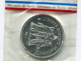 une pièce d'argent dans un sac en plastique sur une surface blanche