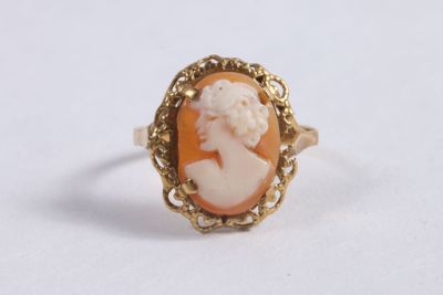 gros plan d'une bague en or avec un camée représentant une femme
