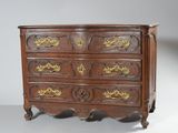 une commode ancienne ornée de décorations dorées sur les tiroirs