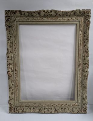 an old picture frame sitting on top of a table next to a vase