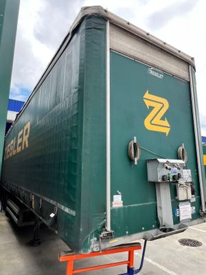 a green semi truck with a yellow z logo on the side