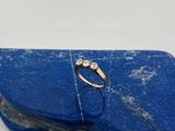 une image d'une bague en diamant posée sur une pierre bleue