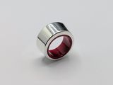 a close up of a ring with a red center on a white surface