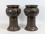 une paire de vases anciens en bronze sur socles, sur fond blanc