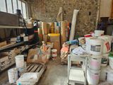 several buckets of paint are stacked on pallets in a warehouse