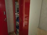 a red and white closet with a red door in a room