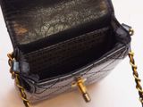 a black purse with a gold chain hanging from it
