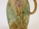 un vase vert orné d'une fleur violette