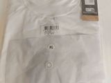 Le t-shirt est blanc et comporte une étiquette noire.