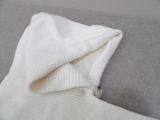a white sweater that is folded over on a couch