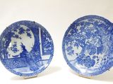 une paire d'assiettes bleues et blanches ornées de motifs, posées sur une table