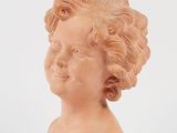 a clay head of a child on a white surface