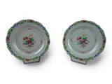 two plates with floral designs on them on a white surface