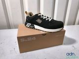 black and white sneakers with white laces are on a cardboard box