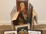 a pile of framed pictures on the floor next to a pile of framed pictures