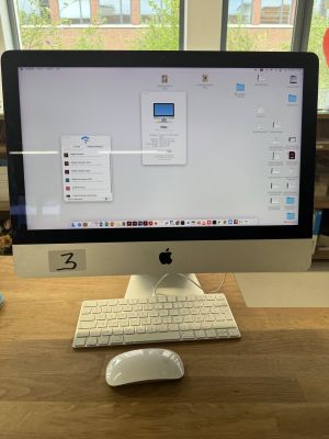 a computer monitor sitting on a desk with a keyboard and mouse