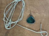 silver necklace with a green stone pendant and a silver necklace with a green stone pendant