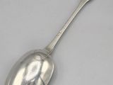 a silver spoon on a white surface with a spoon in the middle of it