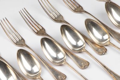 beaucoup de cuillères et de fourchettes en argent sur une table blanche