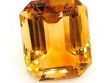 gros plan d'un diamant jaune sur une surface blanche