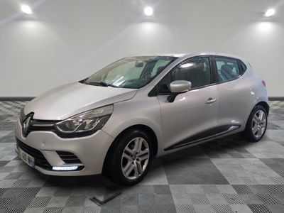 une voiture argentée est garée dans une pièce au sol en damier