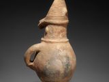 a close up of a vase with a hat on top of it
