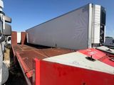 two semi trucks parked next to each other on the side of the road