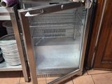a microwave sitting inside of a glass door in a kitchen