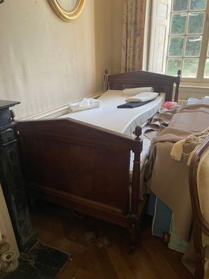 un lit dans une chambre avec une cheminée et un miroir
