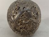 an image of a metal ball with a dragon design on it