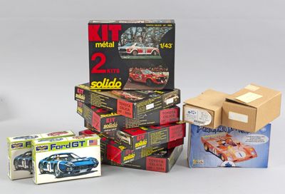Plusieurs boîtes contenant des modèles réduits de voitures de différents types sont empilées les unes sur les autres.