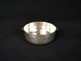 a silver plated bowl on a black background