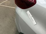 a sticker on the back of a car that is parked in a parking lot