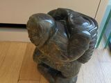 a statue of a man holding a baby on the floor
