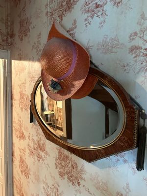 un chapeau accroché au mur à côté d'un miroir
