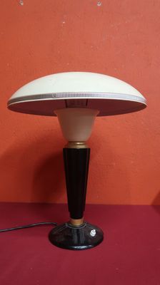 une photo d'une lampe de table posée sur une surface rouge
