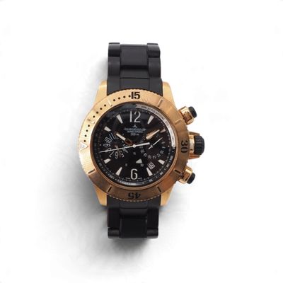 La montre est noire et dorée, avec un cadran noir.
