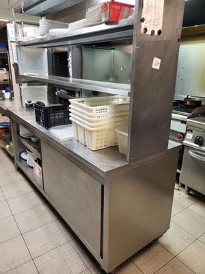 une grande cuisine avec de nombreux plans de travail en inox