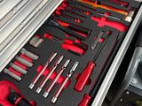de nombreux outils dans une boîte à outils posée par terre