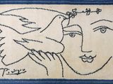 a blue and white rug with a drawing of a woman and a bird