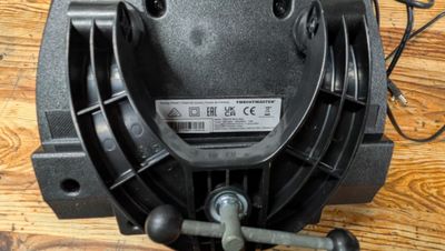 vue de dessus d'un moteur de ventilateur noir posé sur un plancher en bois