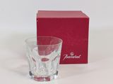 une boîte rouge et un verre posés sur une surface blanche