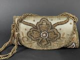 a gold beaded clutch bag with a flower design on the front