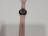 a close up of a watch on a white surface with a pink strap