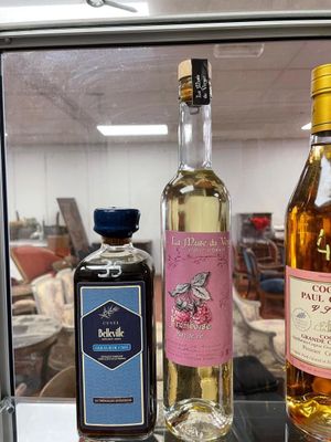 three bottles of alcohol sitting on a glass shelf